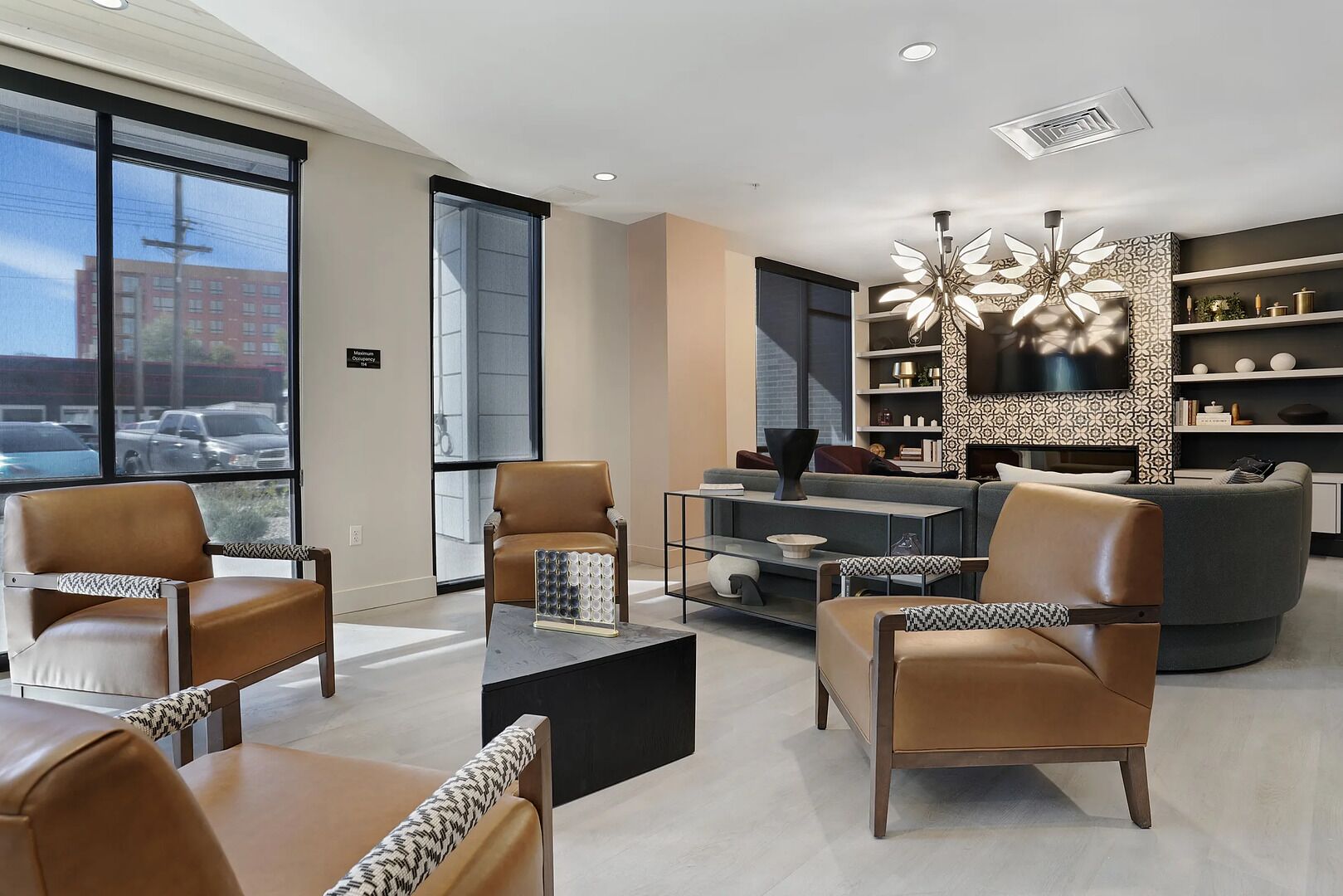 A modern living room with leather sofas, a coffee table, and a large TV.