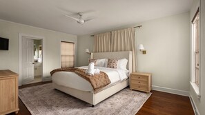 A bedroom with a bed, bedside tables, a ceiling fan, a window with curtains, and a wall-mounted lamp. - Southern Charm Off The Square+Sleeps 10+Firepit (Georgetown)