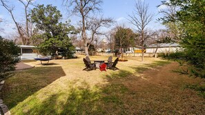 A backyard with a wooden table and chairs, a hammock, and a swing set. - Southern Charm Off The Square+Sleeps 10+Firepit (Georgetown)