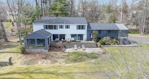 Une maison à deux étages dotée d’un patio couvert et d’un garage séparé.