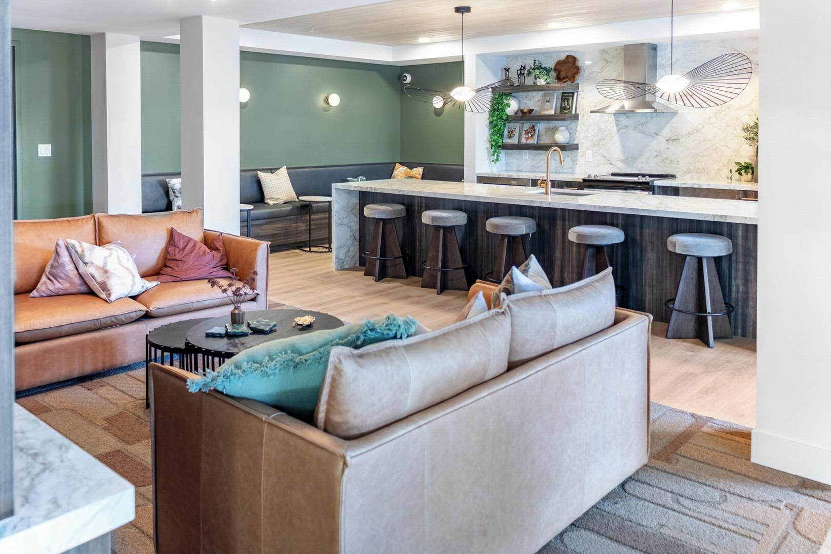 A modern living room with a sofa, a coffee table, and a bar area with stools.