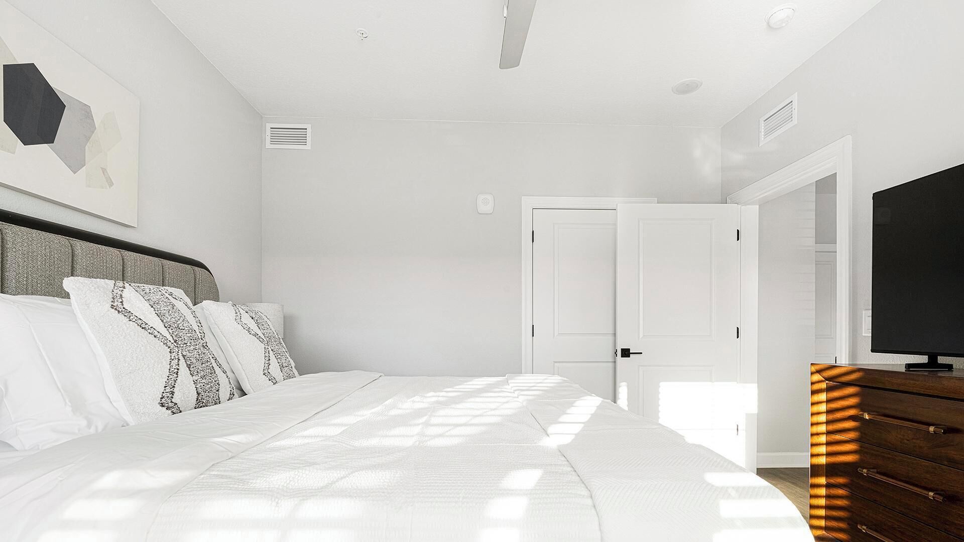 Ein Schlafzimmer mit einem Bett, einem Fernseher und einem Schminktisch.