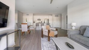 A modern apartment with a dining area, kitchen, and living room. - Landing | Stylish 2BD, Pool (Tice)
