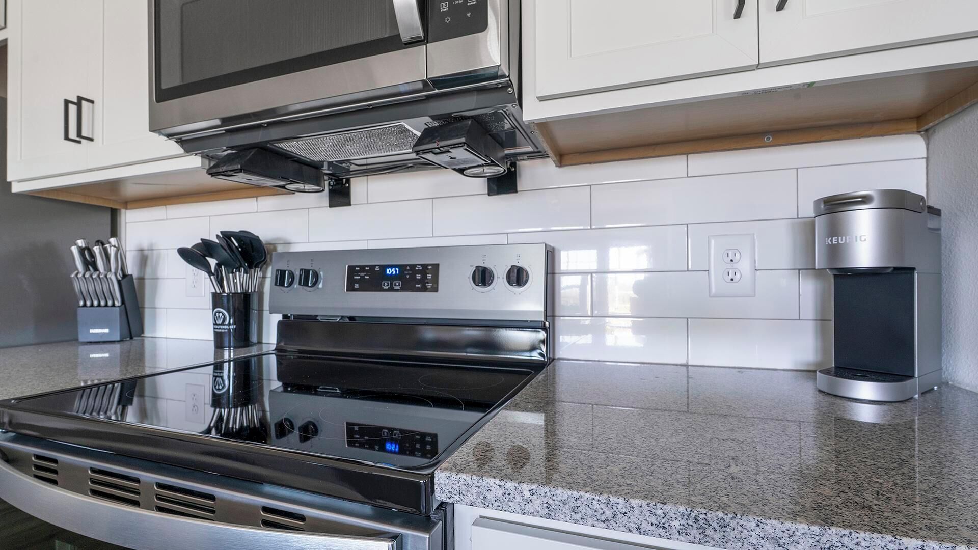 A modern kitchen with stainless steel appliances, a built-in oven, and a coffee maker.