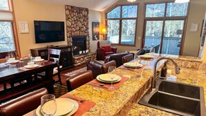 Una cocina con encimeras de granito, un lavamanos empotrado y una chimenea de piedra.