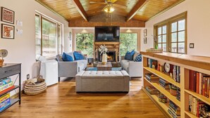 A spacious living room with a fireplace, two sofas, a coffee table, and a bookshelf.