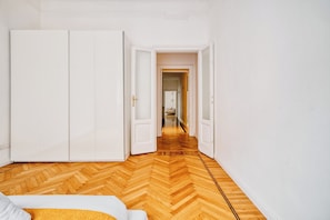 A room with a wooden herringbone floor, white walls, and a large wardrobe. - Milano Isola Luxury Living; big Terrace (Milan)