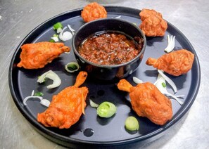 Un plato con alimentos fritos y un tazón de salsa.