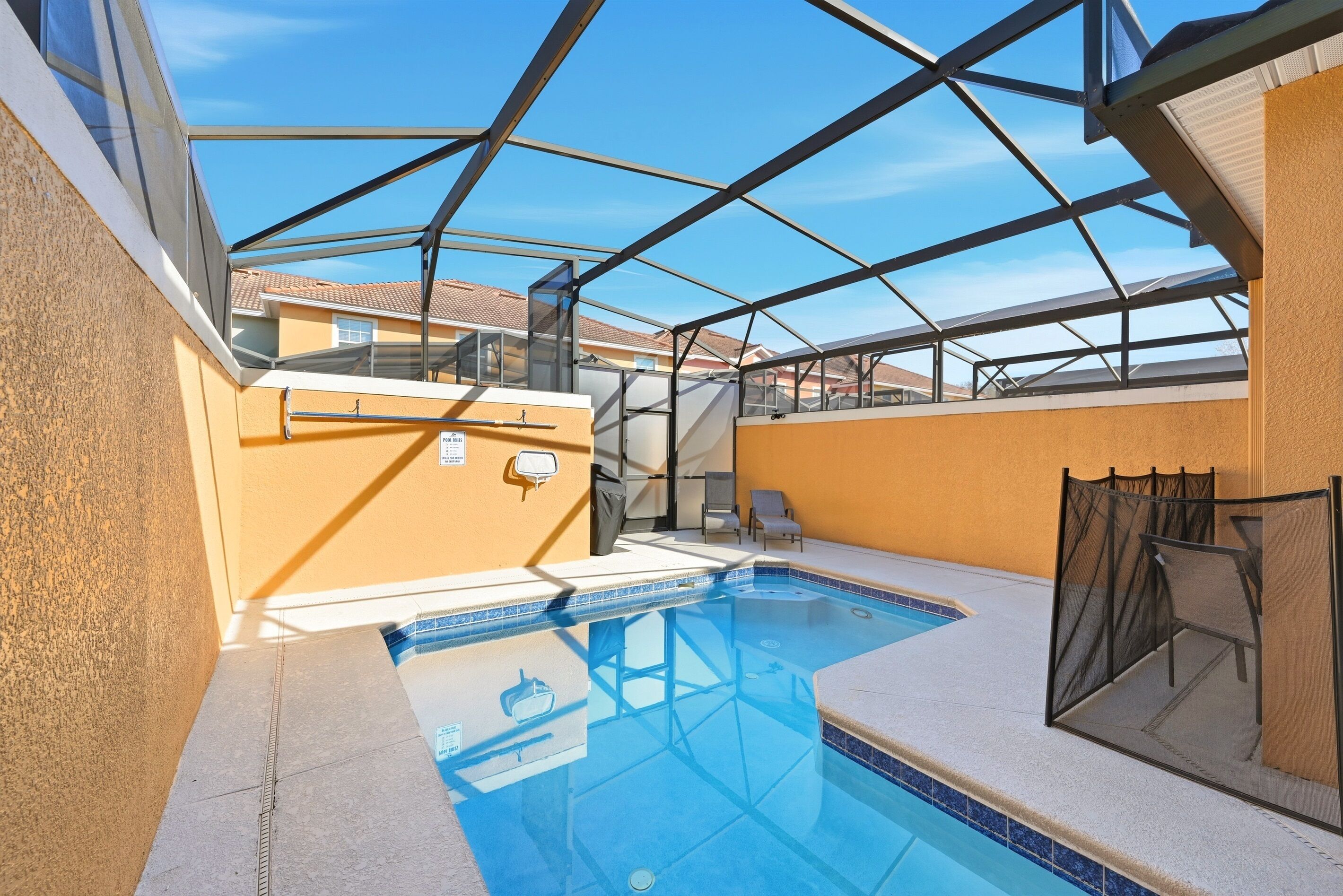 An indoor swimming pool with a glass ceiling, surrounded by beige walls and a tiled floor.
