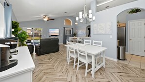 Una cocina moderna con comedor, ventilador de techo y vistas al exterior.