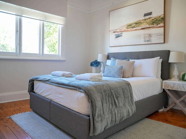 A bedroom with a bed, a window, a painting, and a nightstand. - William Cottage • Walkable CBD Base • Bathurst (Bathurst)
