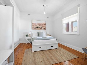 A bedroom with a bed, a bedside table, a window, and a painting on the wall. - William Cottage • Walkable CBD Base • Bathurst (Bathurst)