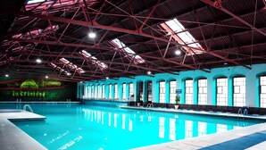 An indoor swimming pool with a high ceiling, large windows, and a blue and white color scheme. - Centro Vacacional La Trinidad (Santa Cruz Tlaxcala)