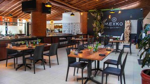 A restaurant with wooden tables and chairs, a bar area, and a black wall with 'MEXKO' branding. - Centro Vacacional La Trinidad (Santa Cruz Tlaxcala)