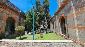A courtyard with stone walls, a street lamp, and outdoor seating. - Centro Vacacional La Trinidad (Santa Cruz Tlaxcala)