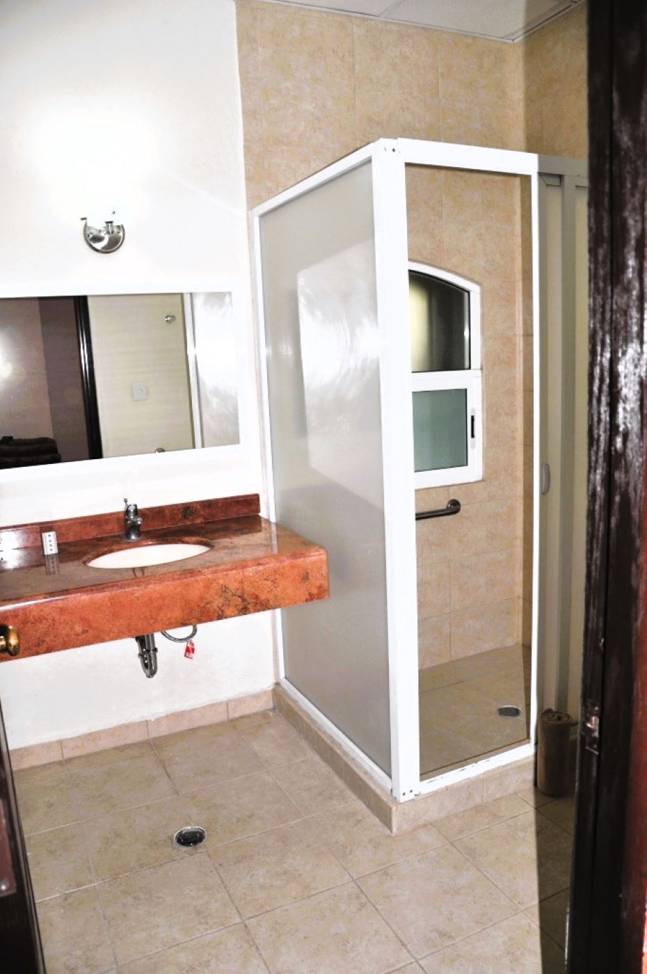 Une salle de bain équipée d’un lavabo, d’un miroir et d’une cabine de douche.