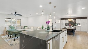 A modern kitchen with a central island, white cabinetry, and pendant lighting. - Modern, spacious 6 BR/4 Bath house close to Old Town Scottsdale with Heated Pool (Scottsdale)