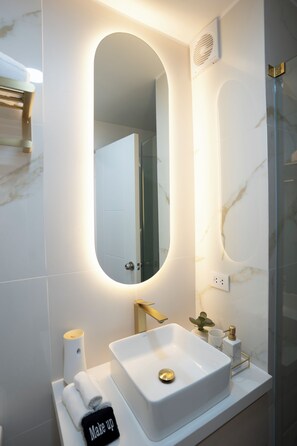 A modern bathroom with a large oval mirror, a white sink, and a towel rack with a towel labeled "Make up". -  Miraflores Prime Apartment-3 blocks to Kennedy Park (Miraflores)