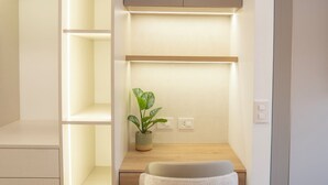 A modern, well-lit room with a built-in desk, a chair, and a potted plant. -  Miraflores Prime Apartment-3 blocks to Kennedy Park (Miraflores)