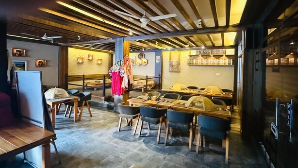 Un ristorante con tavoli e sedie in legno, una zona bar e un attaccapanni con diversi articoli.