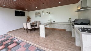 Una cocina moderna con estufa a gas integrada y un comedor con mesa y sillas.