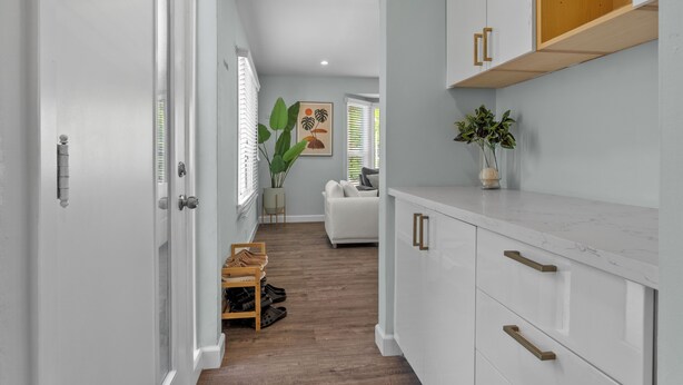 A hallway with white cabinets, a wooden floor, and a plant. - Boho 3BR Alhambra, Sleeps 8, Pet OK, DTLA/Disney/Universal/World Cup/Olympics (Alhambra)