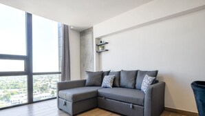 Een moderne woonkamer met een modulaire bank, een groot raam en uitzicht op de stad.
