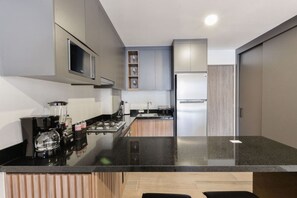 Una cocina moderna con una isla central, electrodomésticos integrados y un diseño minimalista.