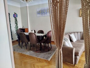 En matplats med ett bord och stolar, en soffa och en dekorativ väggdekoration.