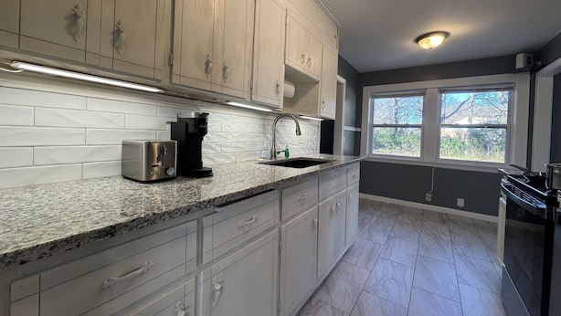 A modern kitchen with white cabinets, granite countertops, and stainless steel appliances. - Fantastic 3-bedroom house with AC in friendly Wichita neighborhood (Wichita)