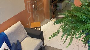 Un salon moderne avec un canapé, une petite table et une plante en pot.