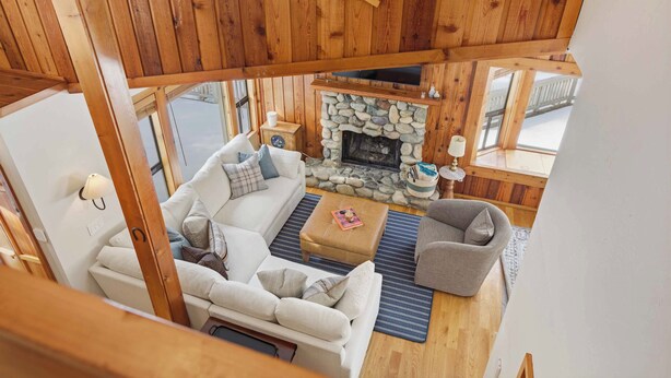 A cozy cabin interior with a stone fireplace, wooden ceiling, and a seating area with a sofa and armchairs. - The Aspen Hideaway | Elkhorn Pool, Hot Tub + Pickleball (Sun Valley)