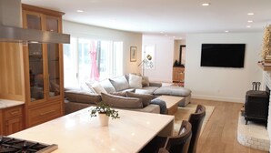 A modern kitchen with a large island, wooden cabinets, and a built-in stove. - Spacious 5-bedroom house in gorgeous, convenient Avon with pool and fitness room (Avon)