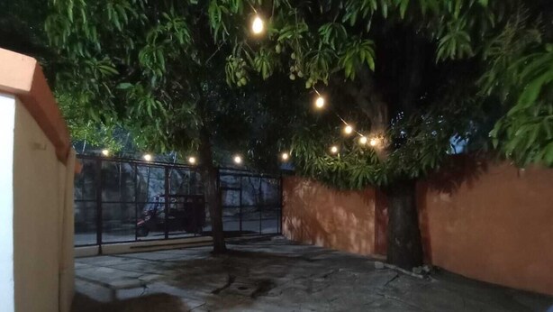 An outdoor area with a concrete floor, a tree, and string lights. - Estancia La Quinta María 2 (Veracruz)