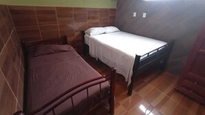 A room with two beds, one larger and one smaller, both with wooden frames. - Estancia La Quinta María 2 (Veracruz)