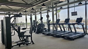 Een sportschool met loopbanden, elliptische trainers en gewichten.