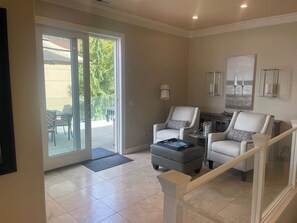 A living room with a sliding glass door leading to an outdoor area, two armchairs, a coffee table, and a lamp. - Luxury 2 story condo on beautiful Lake Washington close to Downtown Kirkland (Kirkland)