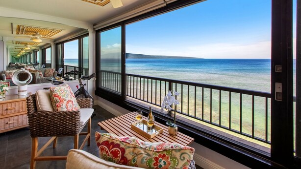 A spacious balcony with a view of the sea, furnished with a table, chairs, and a ceiling fan. - New Listing! Stunning Oceanfront Oasis (Honokowai)
