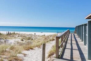 A wooden boardwalk leading to a beach with clear blue water. - Serene 1-bedroom with bunkbeds and sofa sleeper apartment with AC in Panama City (Panama City)