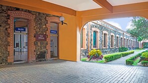 L’entrée d’un hôtel, avec une façade en pierre, une porte en verre et une enseigne indiquant « Hôtel Atlixco ».