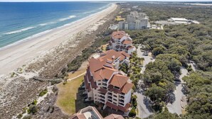 Hotel a la costa amb diversos edificis, platja i vegetació als voltants.