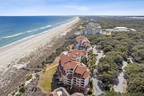 Ein Küstenhotel mit mehreren Gebäuden, einem Strand und umliegender Bepflanzung.