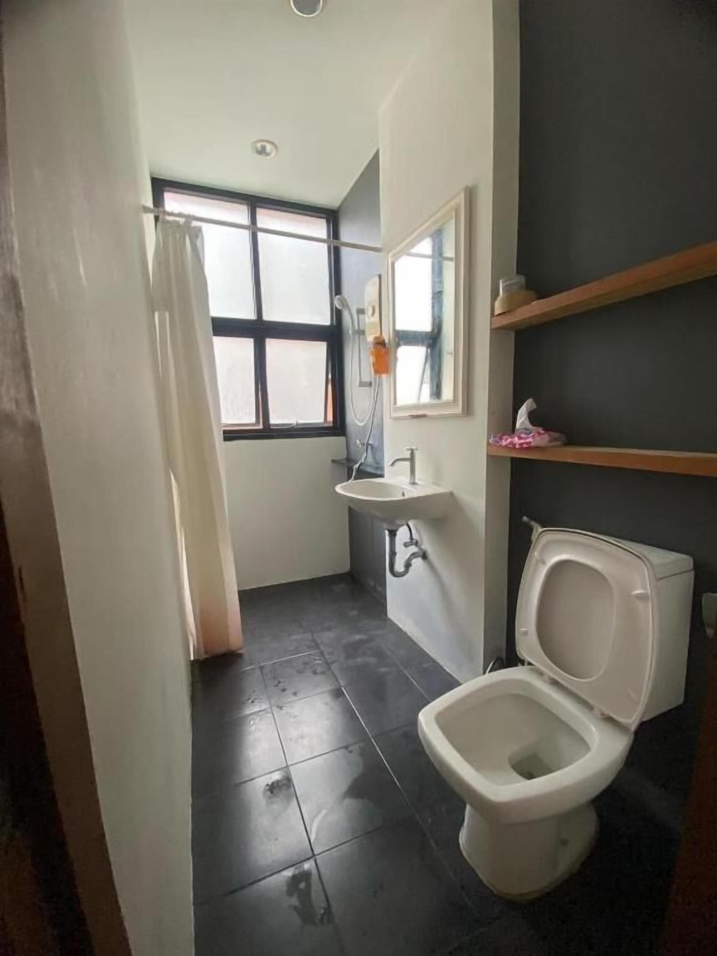 A small bathroom with a toilet, sink, and shower.