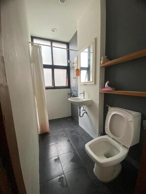 A small bathroom with a toilet, sink, and shower. - Arch Club Patong (Patong)