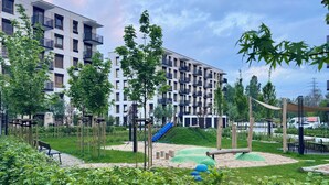 Leikkikentällä on kiipeilytelineitä, liukumäki ja hiekkalaatikko.