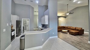 A modern kitchen with white cabinets, a stainless steel refrigerator, and a central island. - Rustic Modern Retreat w/ Private Pool – Leesburg (Leesburg)