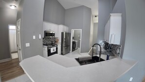 A modern kitchen with stainless steel appliances, a built-in oven, and a large island with a sink. - Rustic Modern Retreat w/ Private Pool – Leesburg (Leesburg)