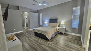 A bedroom with a bed, bedside tables, a ceiling fan, and a walk-in closet. - Rustic Modern Retreat w/ Private Pool – Leesburg (Leesburg)