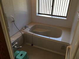 Un baño pequeño con bañera, inodoro y ventana.
