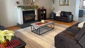 Una sala de estar con chimenea, un sofá, una mesa de centro y una estantería.